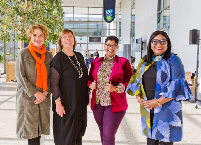 Four UCD alumnae in O'Reilly Hall, posing for a photo.